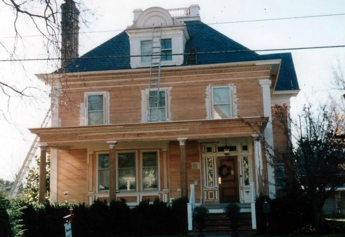 Historic brick-faced home with ornate cornice and dormer during exterior restoration