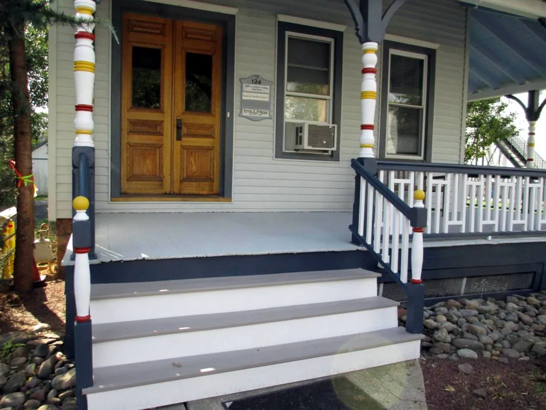 Finished porch with new steps, painted rails and turned posts