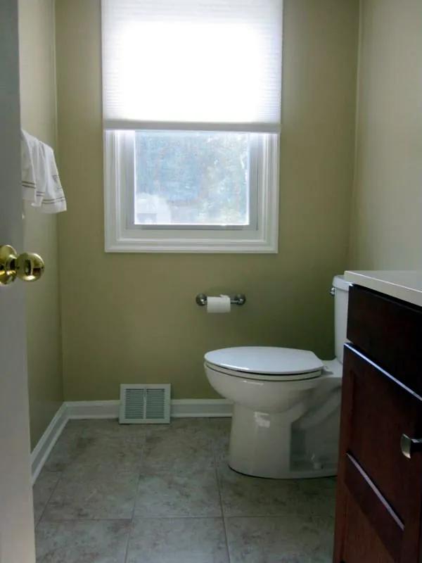 The same powder room finished with new walls, tile floor, toilet and vanity