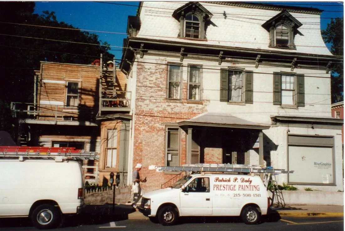 Patrick P. Daly Prestige Painting van parked in front of a historic storefront under restoration