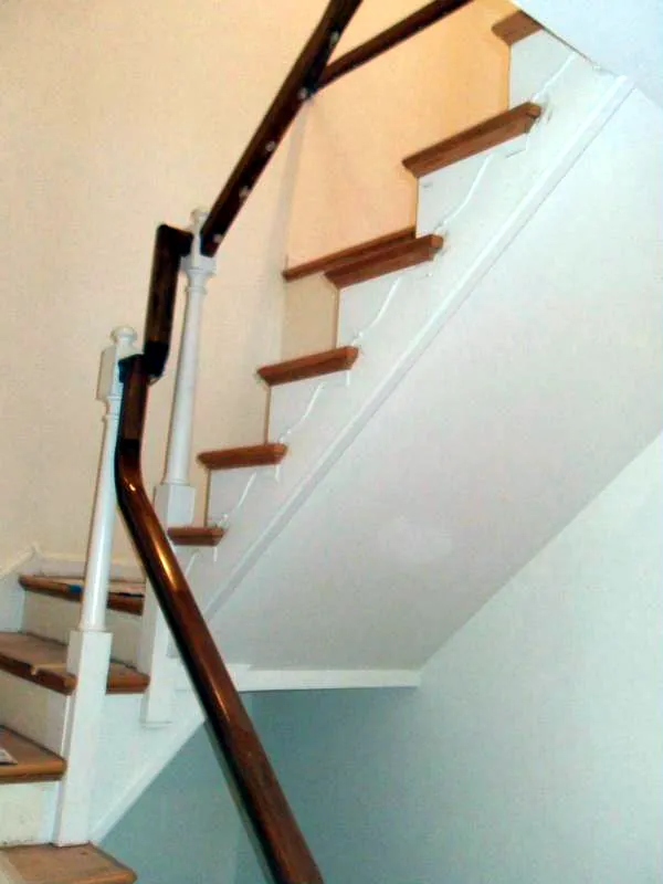 Staircase with oak treads, painted risers and a wood handrail