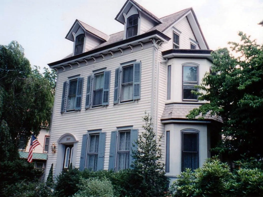 Painted Victorian home with dormers, shutters and a two-story bay window